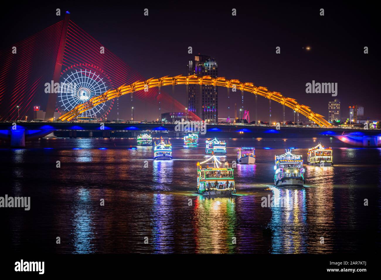 Barche turistiche che si muovono sotto il ponte del Drago alla fine del fuoco Breathing Show, da Nang Vietnam Foto Stock