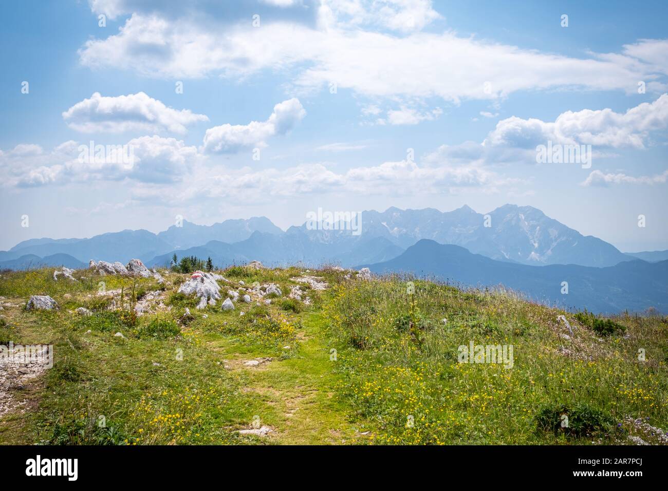 Vista dal Monte Hochobir in Carinzia, Austria con un piccolo sentiero escursionistico di Kamnik-Savinja Alpi in Slovenia su una soleggiata giornata estiva Foto Stock
