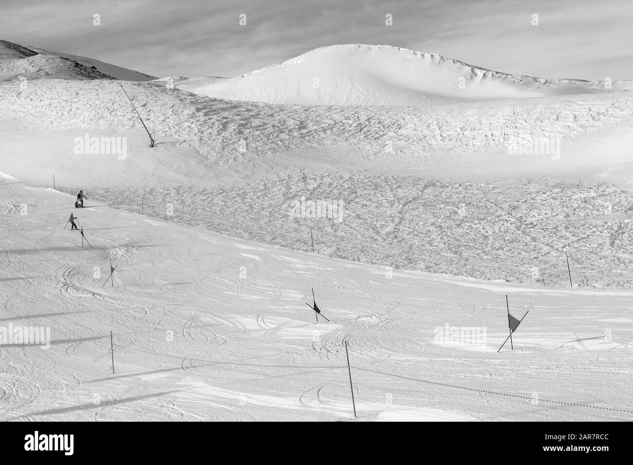 Trace per sci da slalom con i cancelli contrassegnati con bandiere, preparato con il gatto delle nevi e fuori pista pendio nevoso in alta montagna in inverno pieno di sole al giorno. Alpi italiane. Li Foto Stock