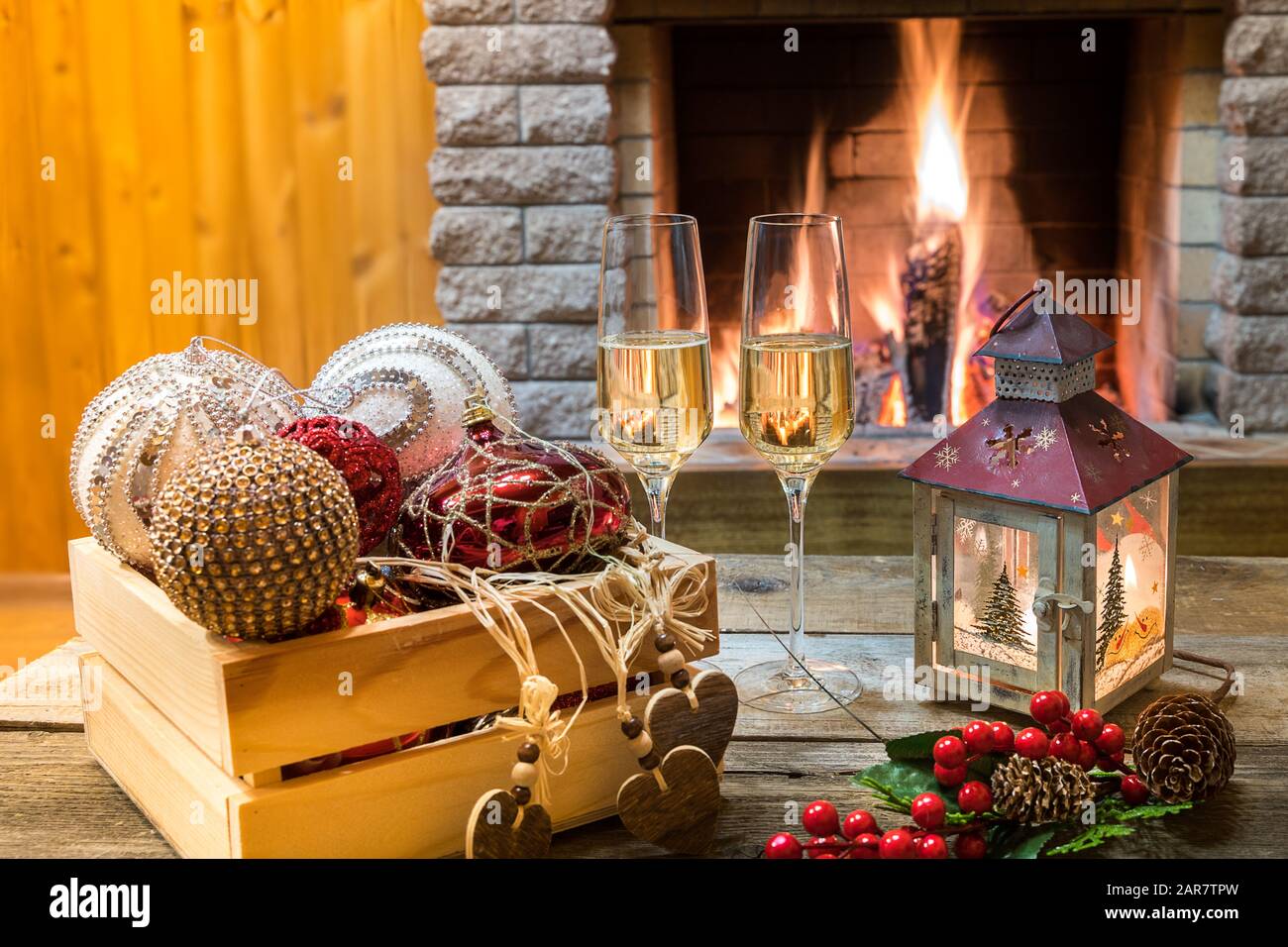 Natale prima di accogliente camino. Due bicchieri di champagne, lanterna di  natale e decorazioni natalizie vicino a un accogliente camino, in casa di  campagna Foto stock - Alamy
