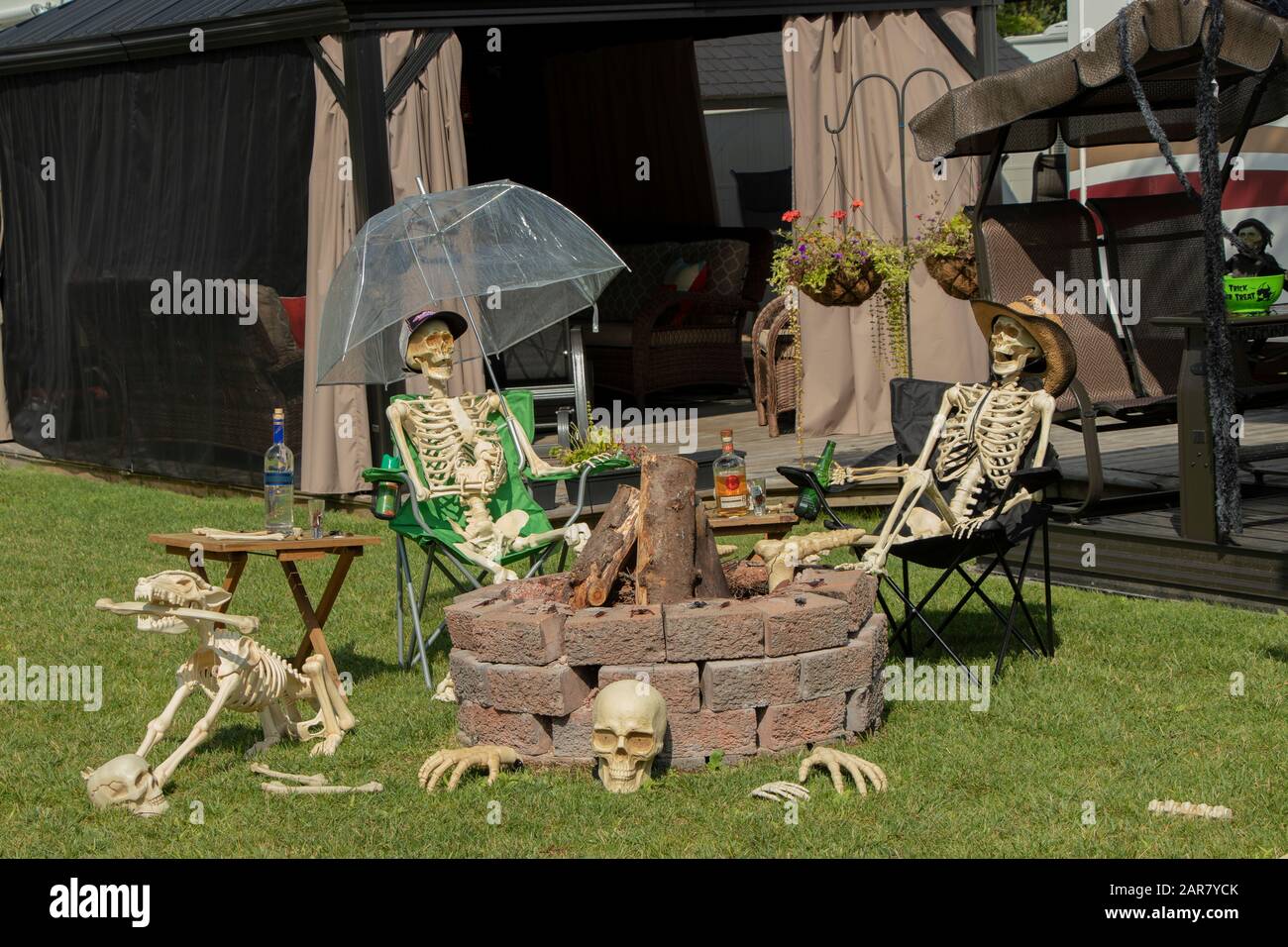 17 agosto 2019 - West Brome, Quebec, Canada: Decorazioni all'aperto di Halloween Skeleton intorno a un anello del fuoco su un campeggio, Camping Vallée Bleue campground Foto Stock