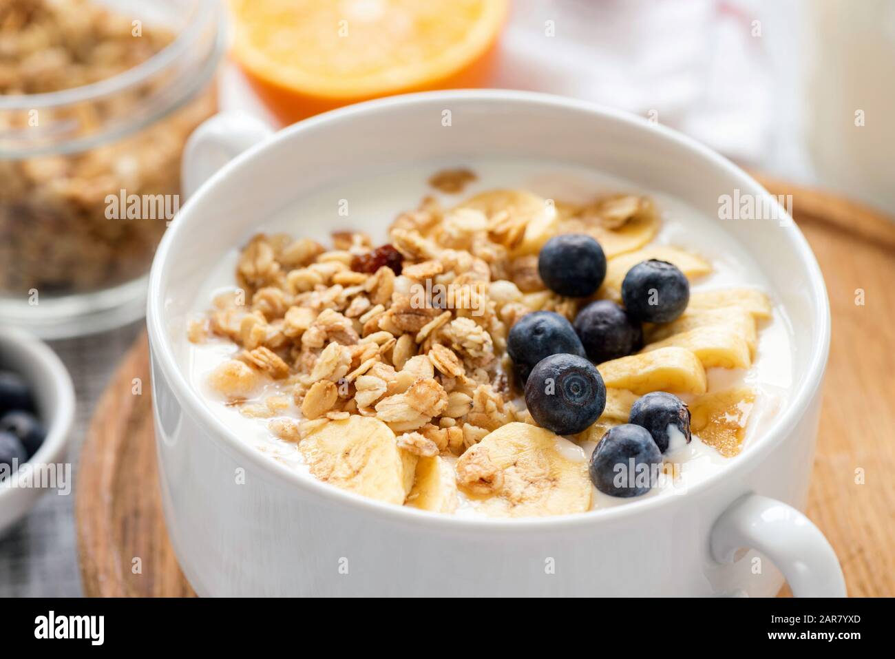 Granola con frutta e yogurt in vaso bianco closeup vista. Cibo sano per la colazione Foto Stock