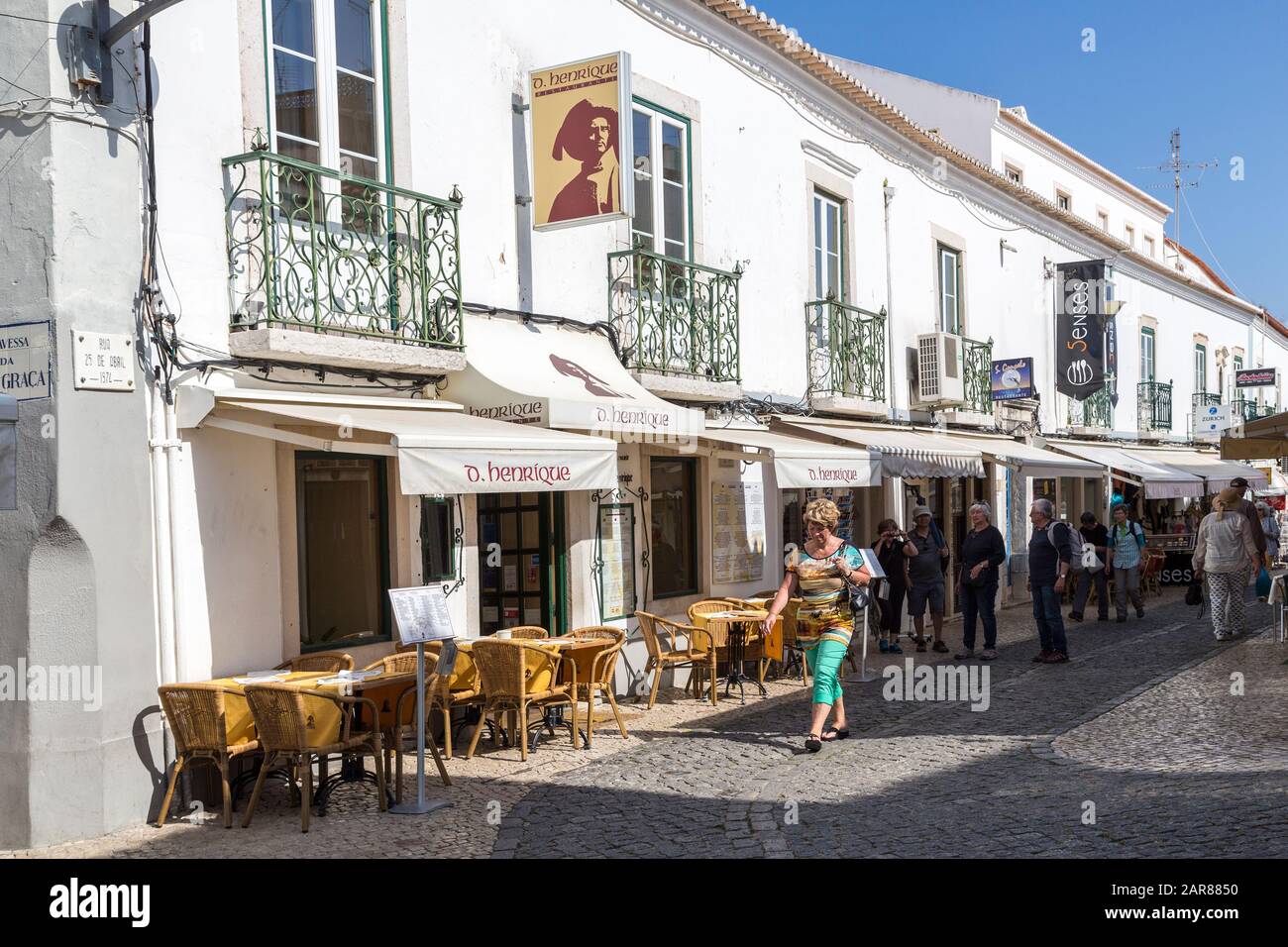 Via dello shopping con tavoli e sedie fuori ristorante, Lagos, Algarve, Portogallo Foto Stock