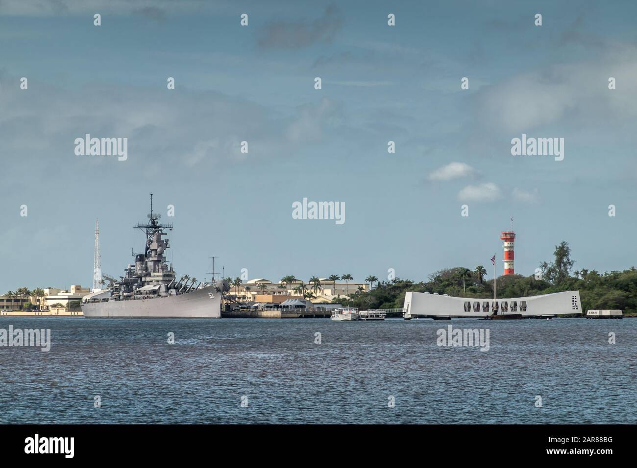 Oahu, Hawaii, Stati Uniti. - 10 Gennaio 2020: Pearl Harbor. La USS Missouri grigia insieme alla USS Arizona Memorial fianco a fianco sull'acqua bluastra e sotto il blu Foto Stock