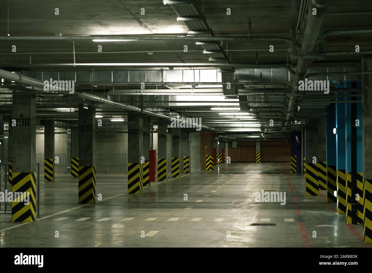 Vista prospettica dell'interno di un'area di parcheggio vuota con file di colonne Foto Stock