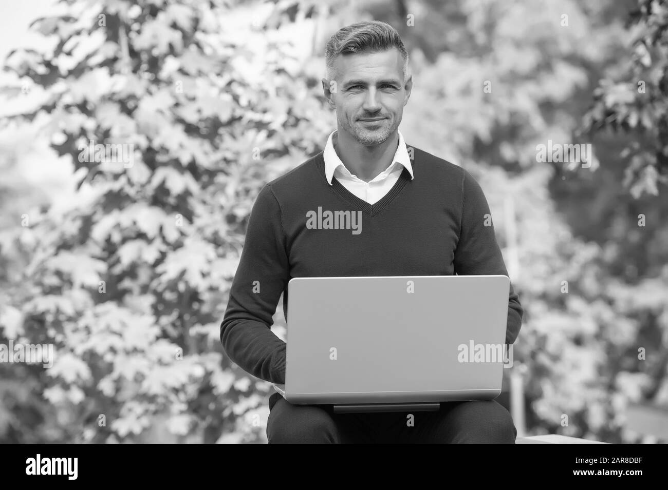 Green office. Ispirando innovazioni. Imprenditore ispirata alla natura guy sentire potente per cambiare il mondo. L'uomo ispirato contenere computer portatile. Ispirato per l'avvio. Ragazzo con computer in giardino. Concetto di freelance. Foto Stock