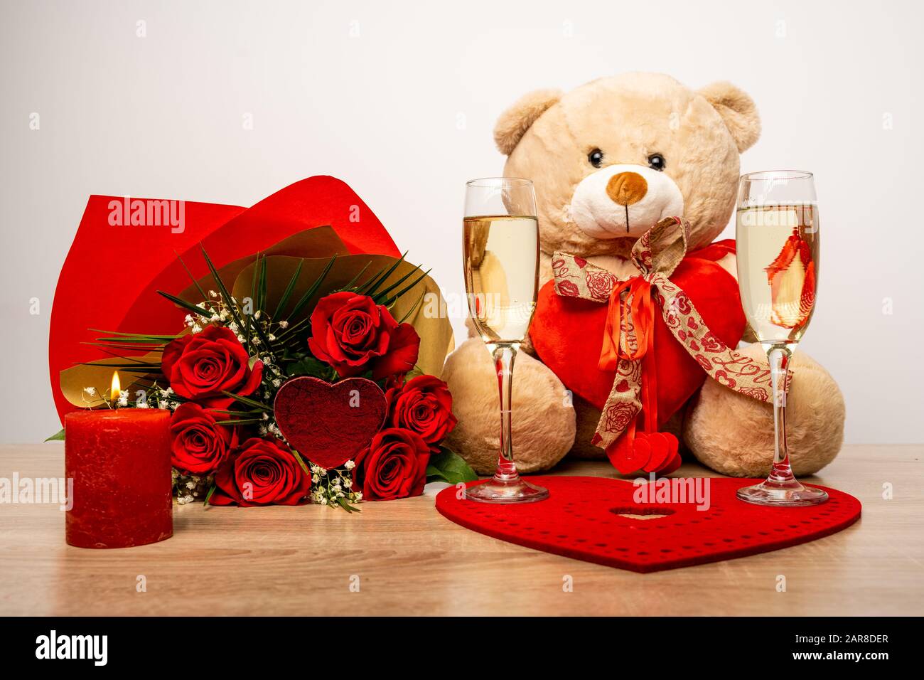 Serata romantica con candela bruciante, bicchieri da vino e bouquet Foto Stock