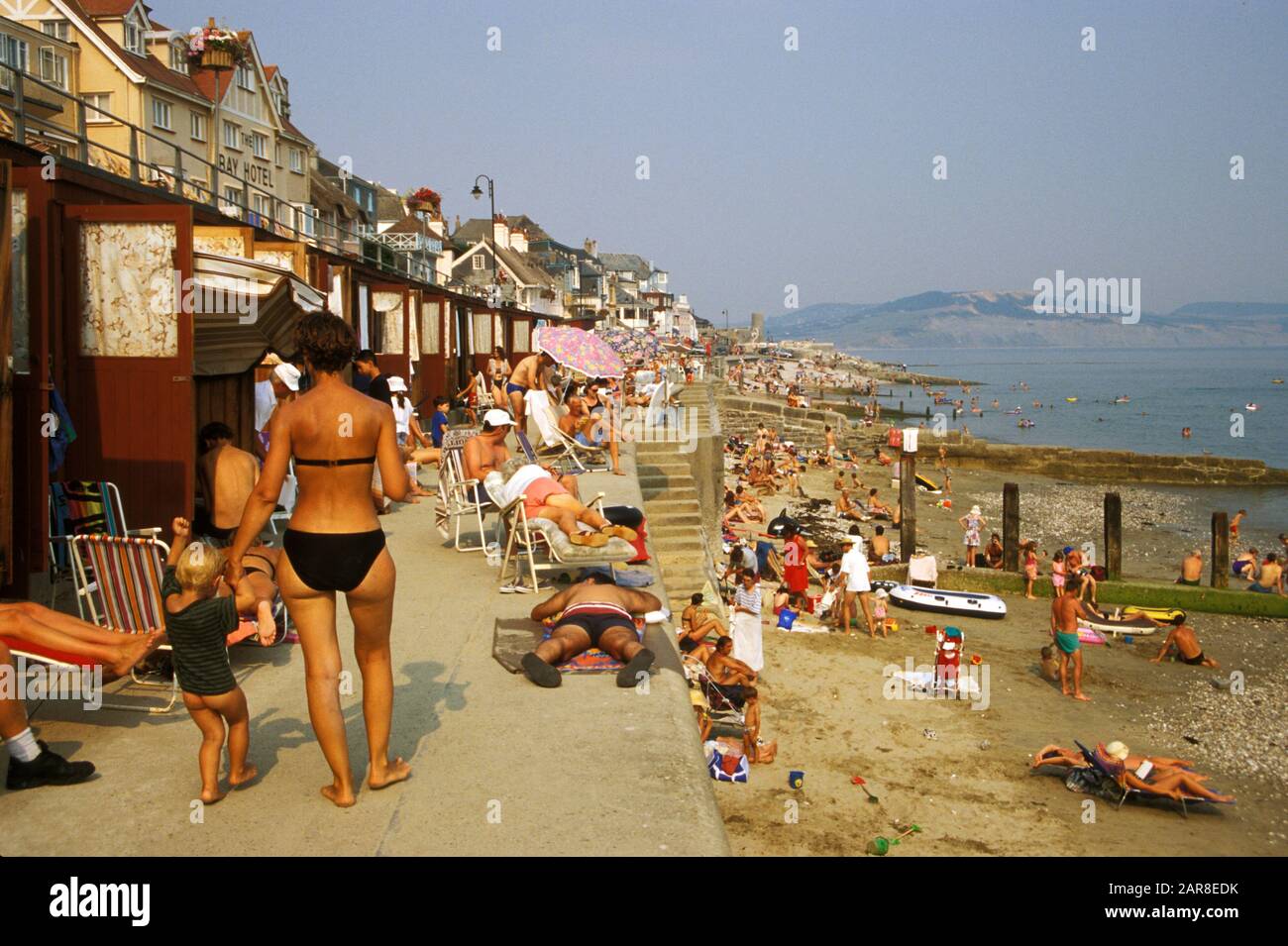 Le famiglie britanniche si riversano sul mare a Lyme Regis, Dorset, nel sud dell'Inghilterra, in un giorno d'estate del 1995. Foto Stock
