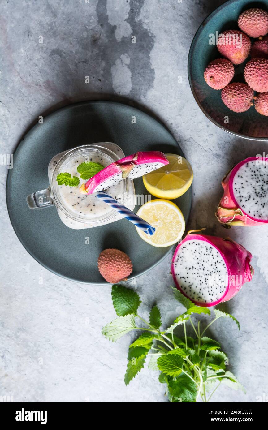 Nutriente Dragon Fruit e Lychee frullato in un vaso di vetro su uno sfondo di pietra Foto Stock