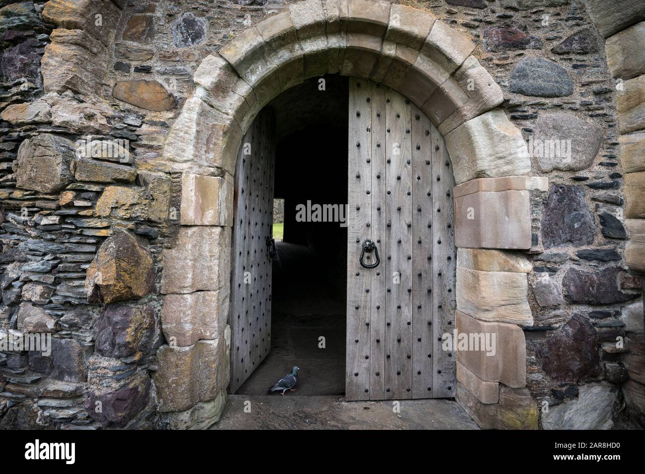 Porta ad arco ha una massiccia porta di legno indossato circondato da mattoni di pietra, Dunstaffnage Castello risalente al 13th secolo è uno dei castelli più antichi Foto Stock