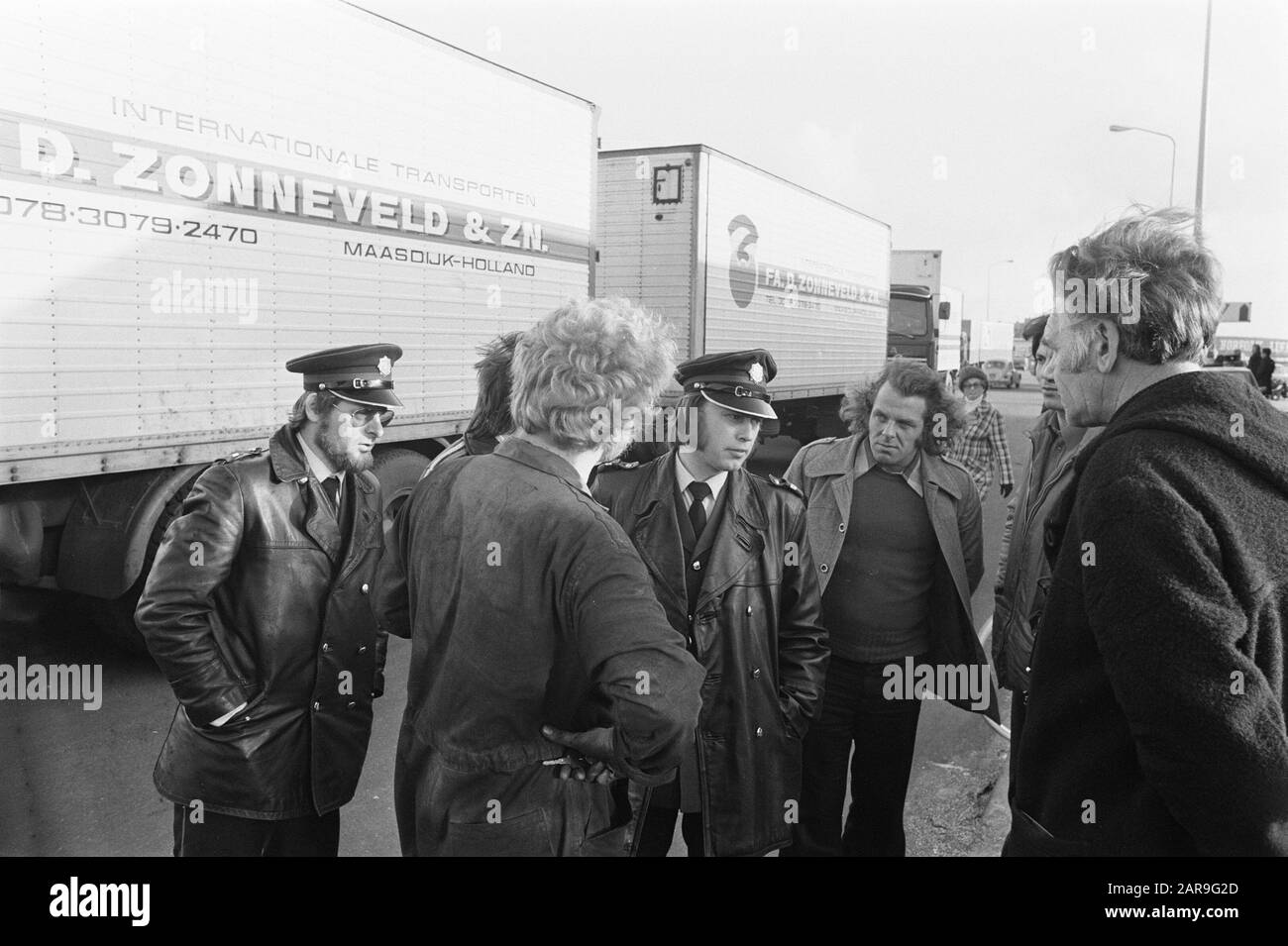 I camionisti bloccano l'accesso a Norfolk Lin a Scheveningen; gli agenti di polizia parlano con i camionisti di rimuovere camion/Data: 26 novembre 1974 Località: Scheveningen, Zuid-Holland Parole Chiave: Conducenti, CAMION, blocchi, polizia Foto Stock