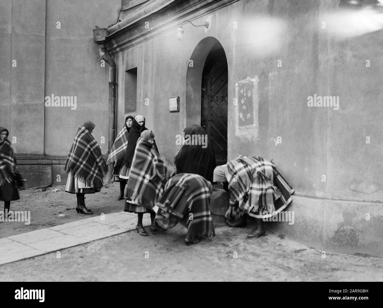 Viaggio in Polonia Donne a Lowicz pulire le scarpe prima di entrare nella chiesa Data: 1934 posizione: Polonia Parole Chiave: Chiesa edifici, costume, cultura popolare Foto Stock