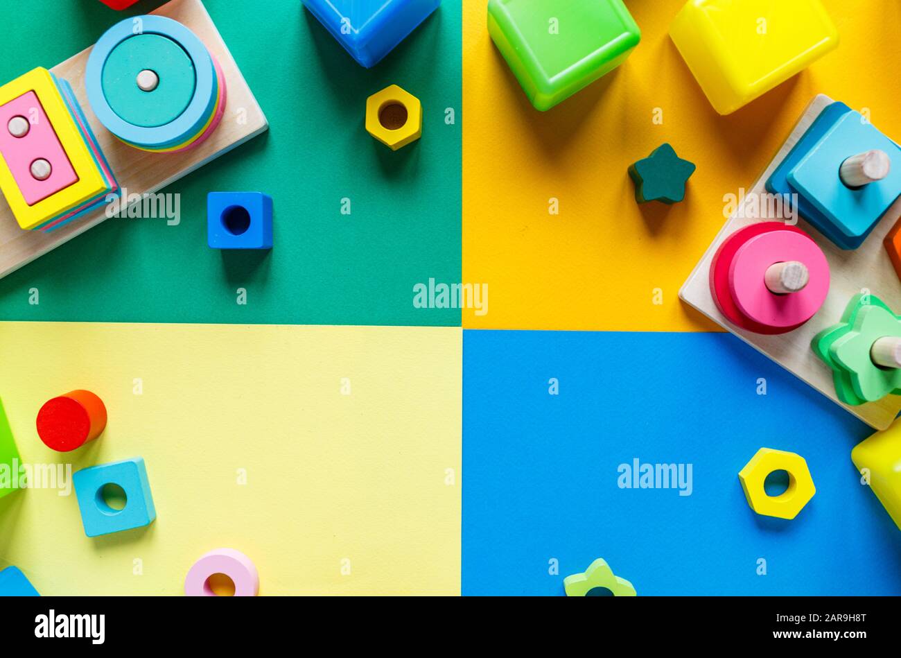 Giocattoli in legno per bambini su carta colorata. Blocchi di giocattoli educativi. Giocattoli per asilo, prescolare o cura del giorno. Copiare lo spazio per il testo. Vista dall'alto Foto Stock