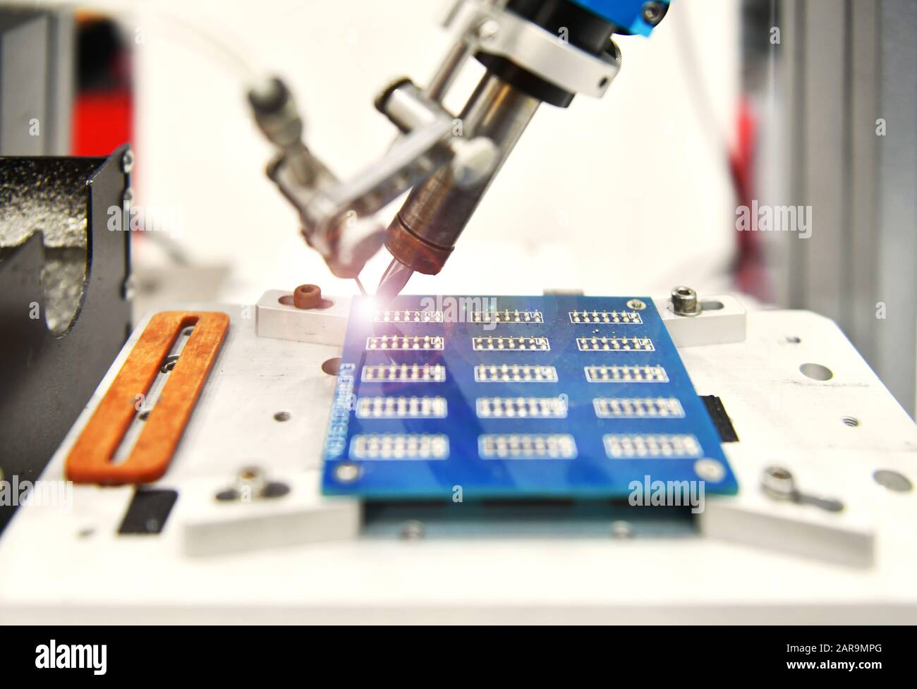 Robot automatico moderno e ad alta tecnologia per la macchina di assemblaggio di schede a circuito stampato (PCB) durante la saldatura o la saldatura di parti o componenti in fabbrica Foto Stock
