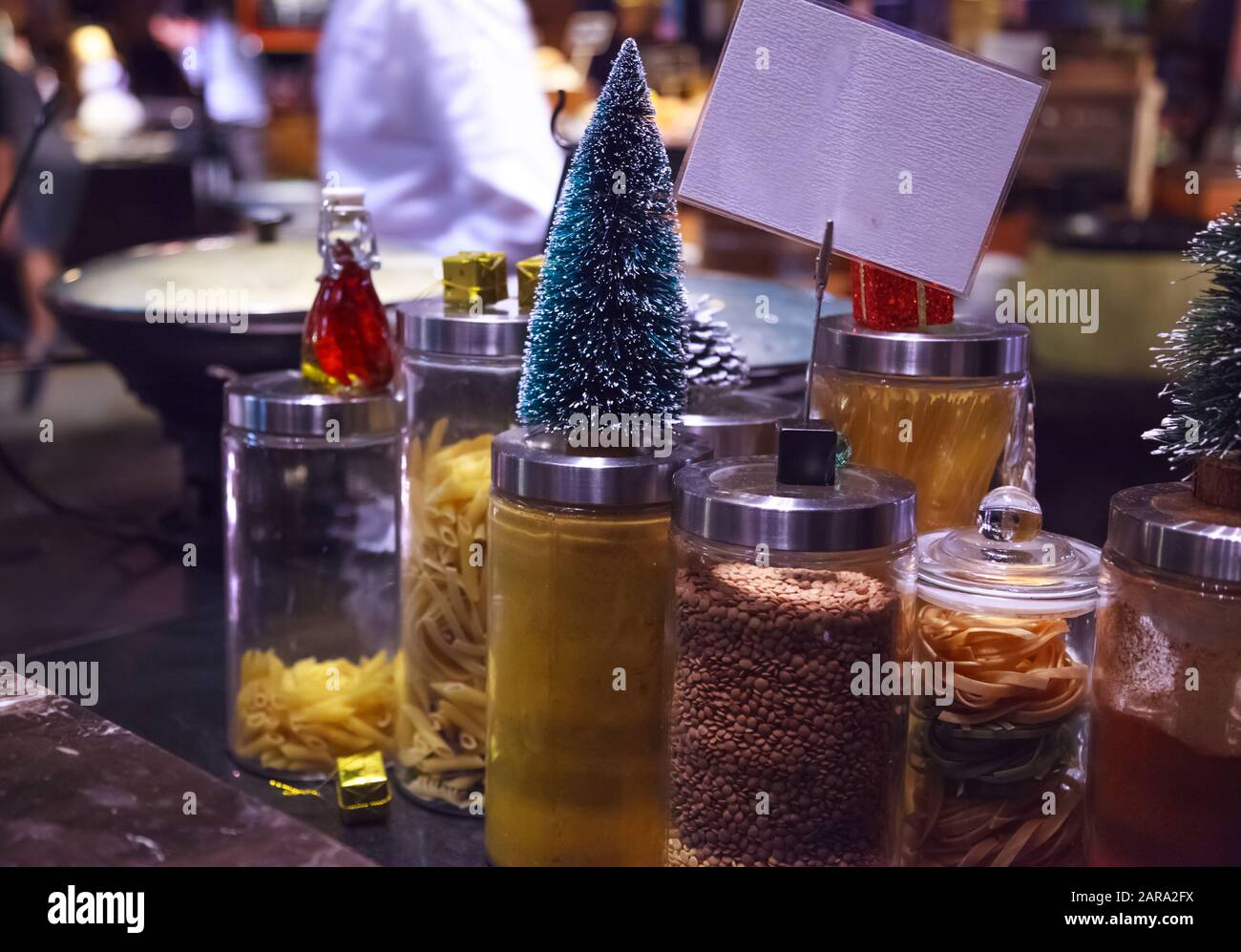 Cucinare i cuochi mantenere asciutto noodle e pasta cibo ingredienti puliti in vasi di vetro in cucina decorato nel tema del Festival di Natale. Cucina, Ricetta, Stagione Foto Stock