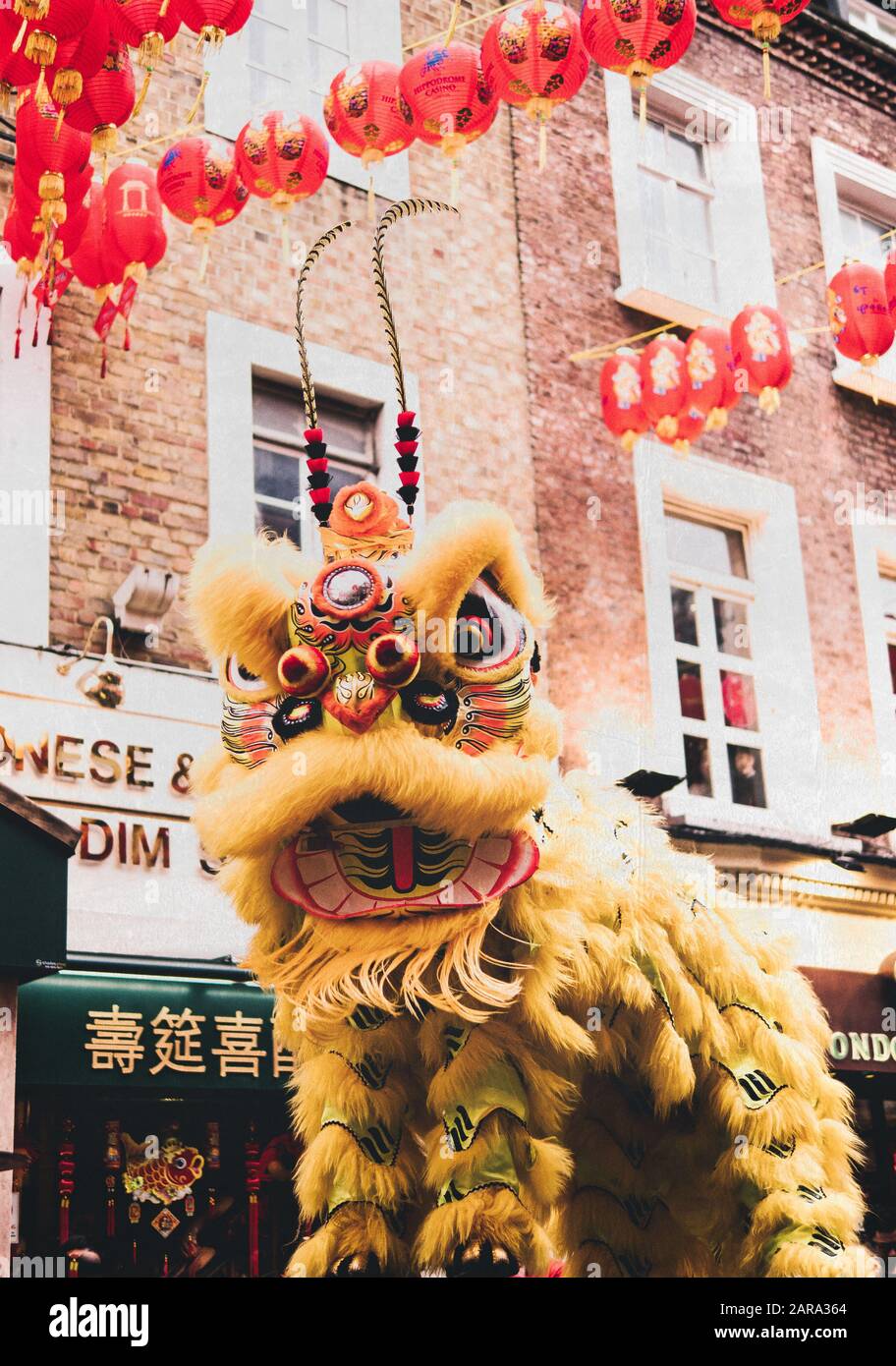 Un leone da ballo giallo in costume per le celebrazioni del Capodanno cinese per l'anno del ratto a Chinatown, Londra. Foto Stock