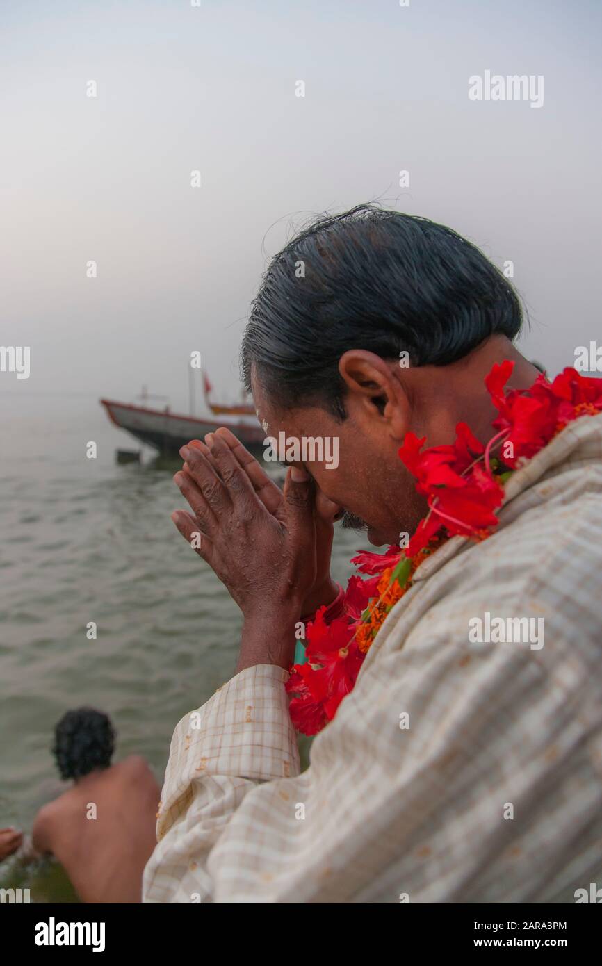 Al mattino, l'uomo che prega ai ghats del fiume santo di Gange, anche il fiume di Ganga, Varanasi anche Benares, Banaras, Uttar Pradesh, India, Asia del sud, Asia Foto Stock