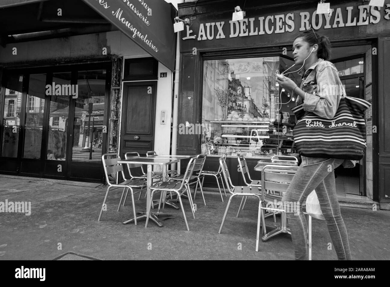 Ragazza che indossa gli auricolari a piedi sul marciapiede, Parigi, Francia, Europa Foto Stock