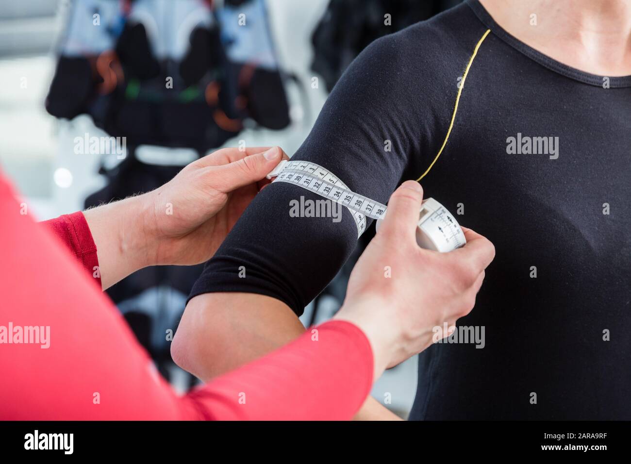 Allenatore di misurazione bicipite muscolo di donna in palestra ems Foto Stock