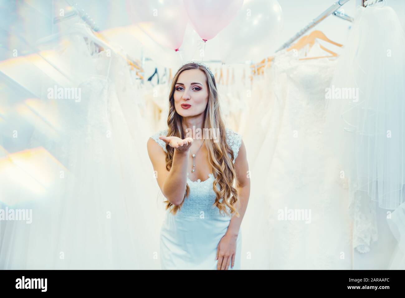 Sposa di essere nel negozio di abbigliamento per matrimoni dando blowkiss Foto Stock