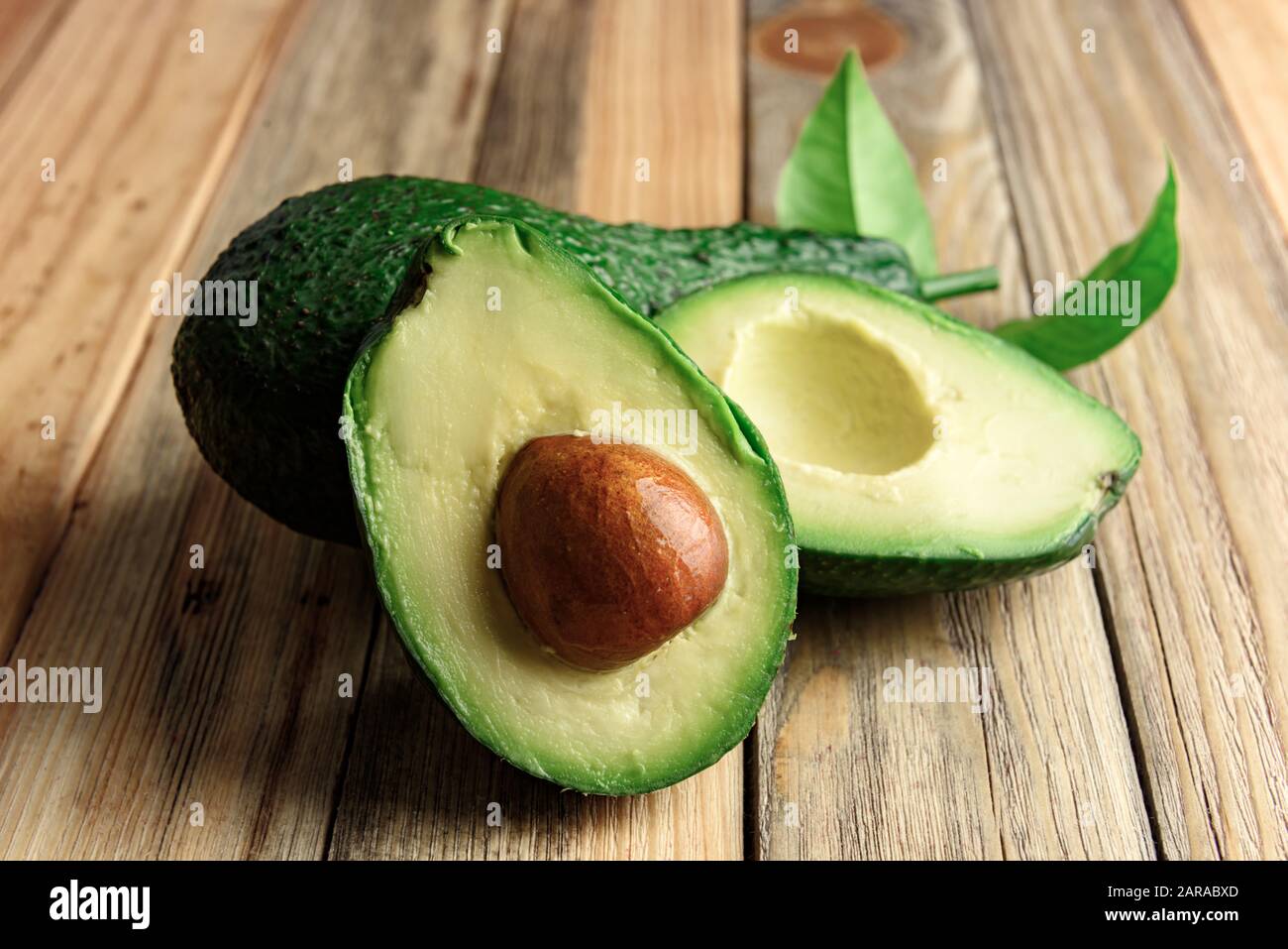 Fresco frutto di avocado su una tavola di legno. Il concetto di mangiare sano. Fotografia di cibo Foto Stock