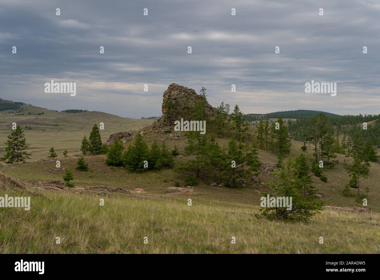 Regione Baikal. Strada sterrata sulla steppa Tazheranskaya vicino alle rocce di pietra, chiamata la Valle degli spiriti di pietra. Foto Stock