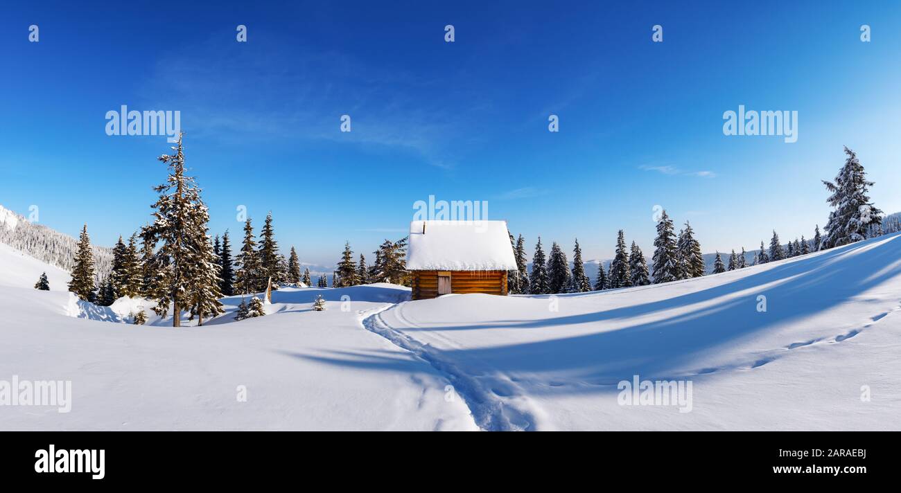 Fantastico paesaggio invernale panoramico con casa in legno su montagne innevate. Concetto di vacanza di Natale. Carpazi Montagna, Ucraina, Europa Foto Stock