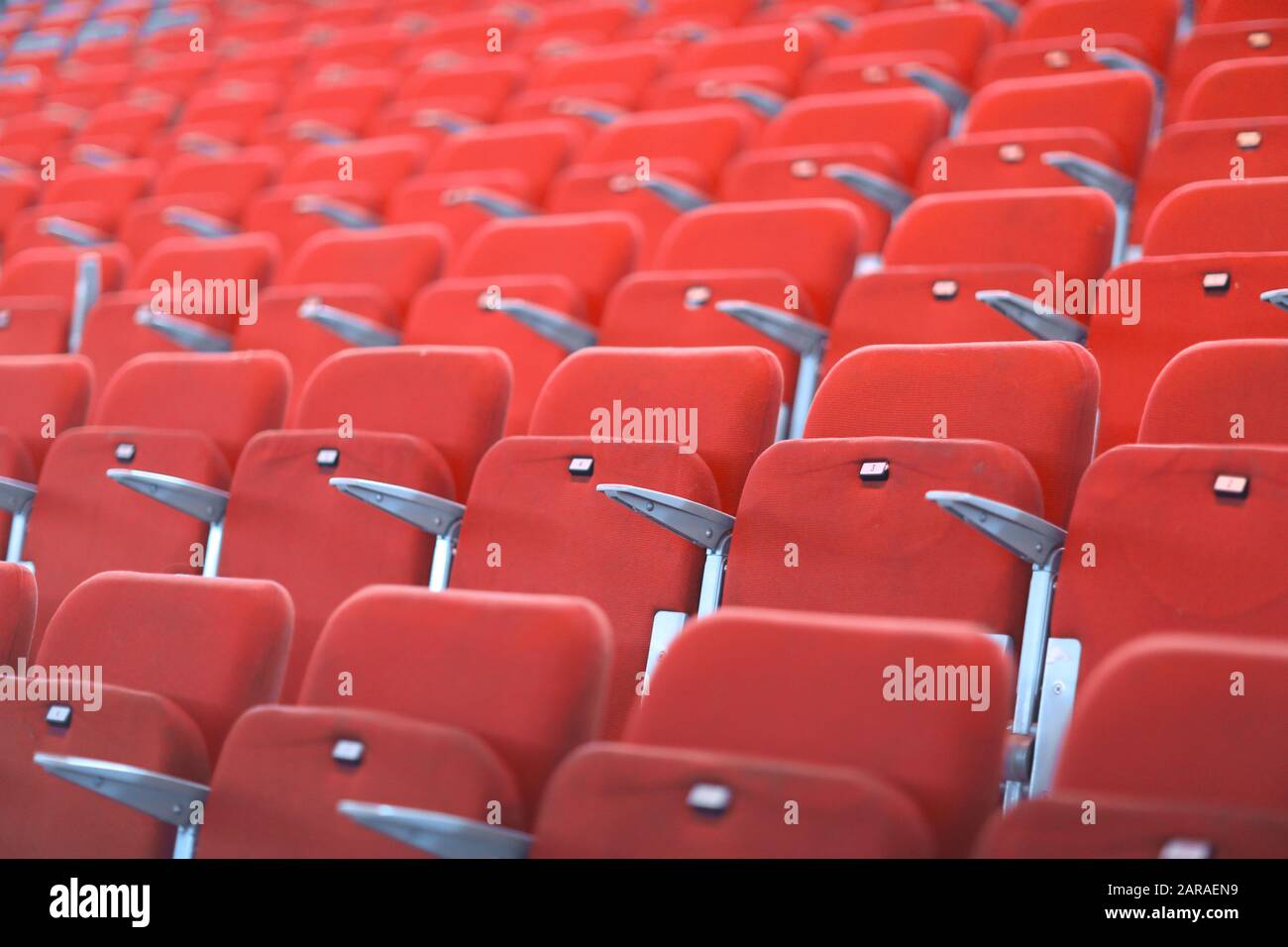 File di sedili numerati in rosso con braccioli in un grande auditorium Foto Stock File di sedili numerati in rosso con braccioli in un grande auditorium Foto Stock