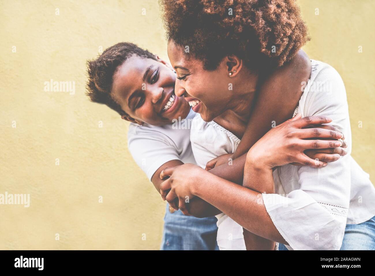 Felice giovane madre divertirsi con il suo bambino - Figlio che abbraccia la sua mamma all'aperto - Famiglia connessione, maternità, amore e teneri momenti di concetto - Focus on w Foto Stock