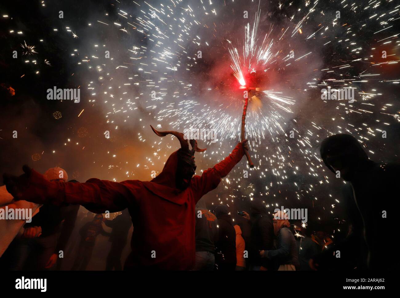 Palma, Spagna. 26th Gen 2020. Un uomo travestito da un demone che tiene fuochi d'artificio passeggiate tra la gente durante il tradizionale Correfoc (focolare) nella fiesta locale di Palma di Maiorca. A Maiorca la domenica sera i demoni del fuoco erano in cammino. I cosiddetti 'dimonis' sono parte integrante delle feste patronali invernali che si svolgono in tutta l'isola nel mese di gennaio in onore dei due santi Sant Antoni (Sant Antonio) e Sant Sebastià (San Sebastiano). (a dpa 'la danza del fuoco diavoli: A Maiorca le scintille sono volare') credito: Clara Margais/dpa/Alamy Live News Foto Stock