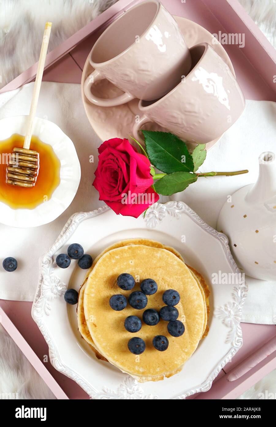 Vassoio per la colazione con pancake e sciroppo e mirtilli frutta layout creativo piatto vista dall'alto. Primo piano verticale. Foto Stock