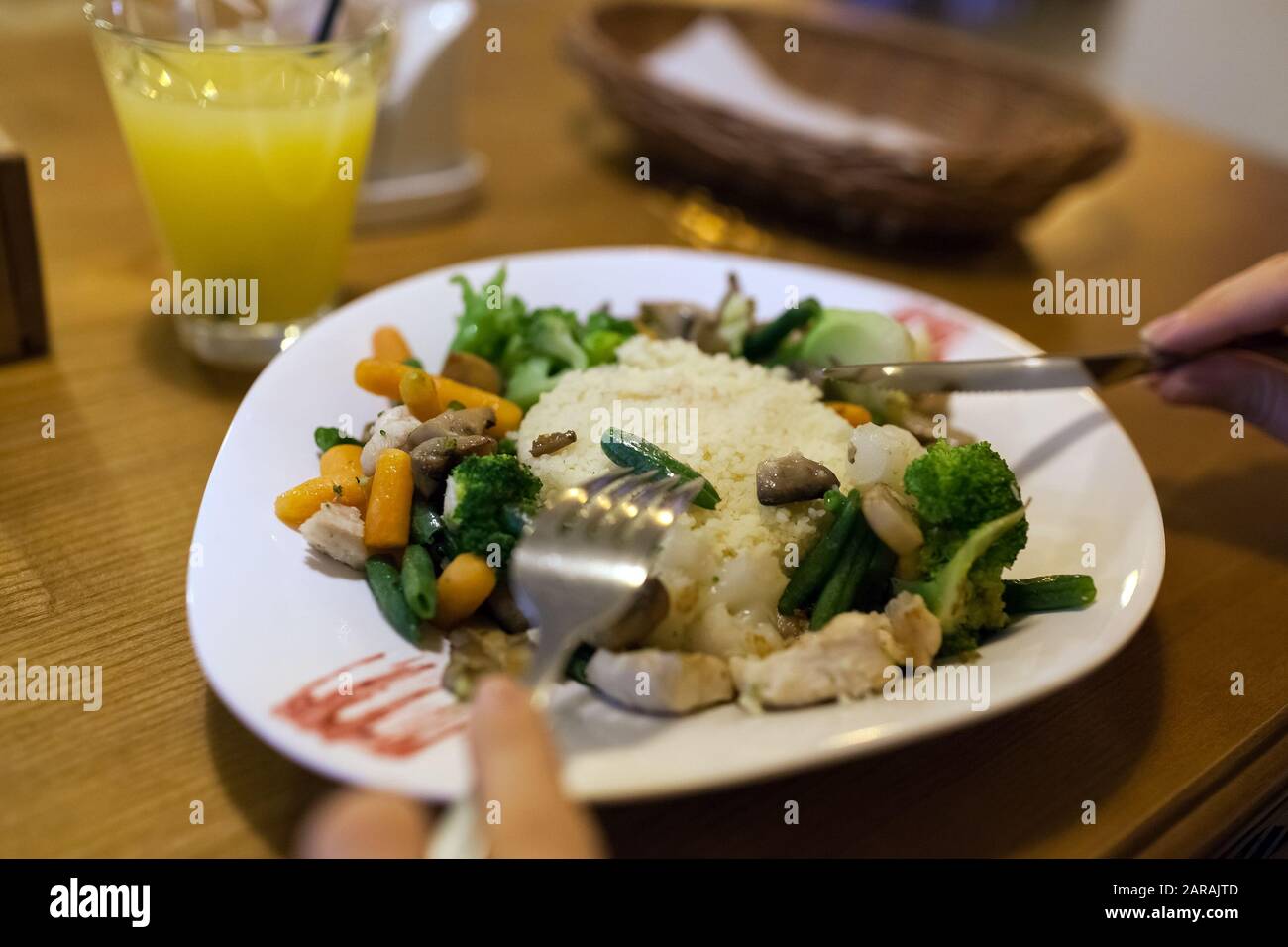 Couscous con pollo, verdure fresche servite con succo nel ristorante. Piatto con carote, broccoli, funghi Foto Stock