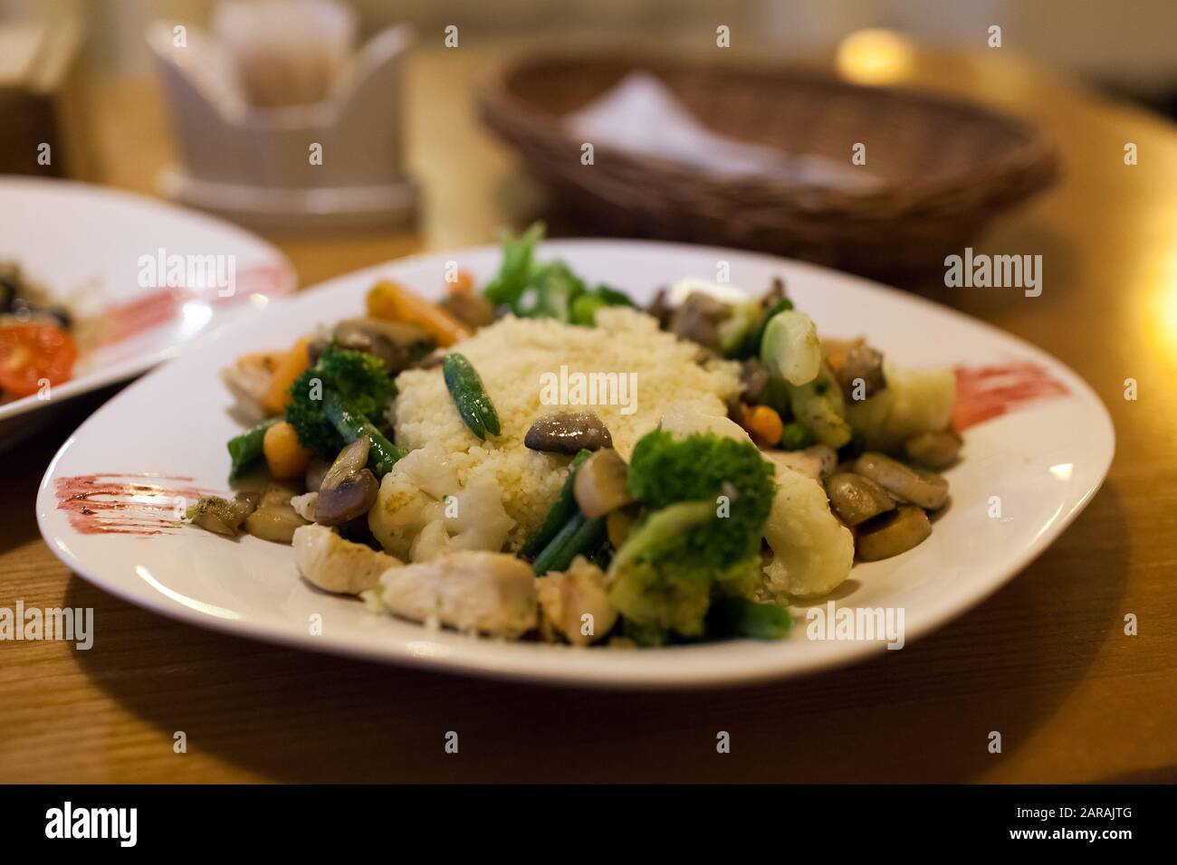 Couscous con pollo, verdure fresche servite con succo nel ristorante. Piatto con carote, broccoli, funghi Foto Stock