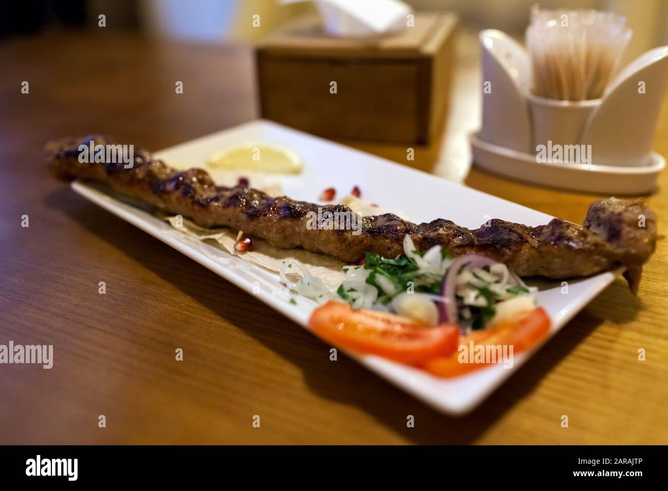 Lula kebab piatto di carne con verdure servito in ristorante su tavolo di legno. Barbecue Foto Stock