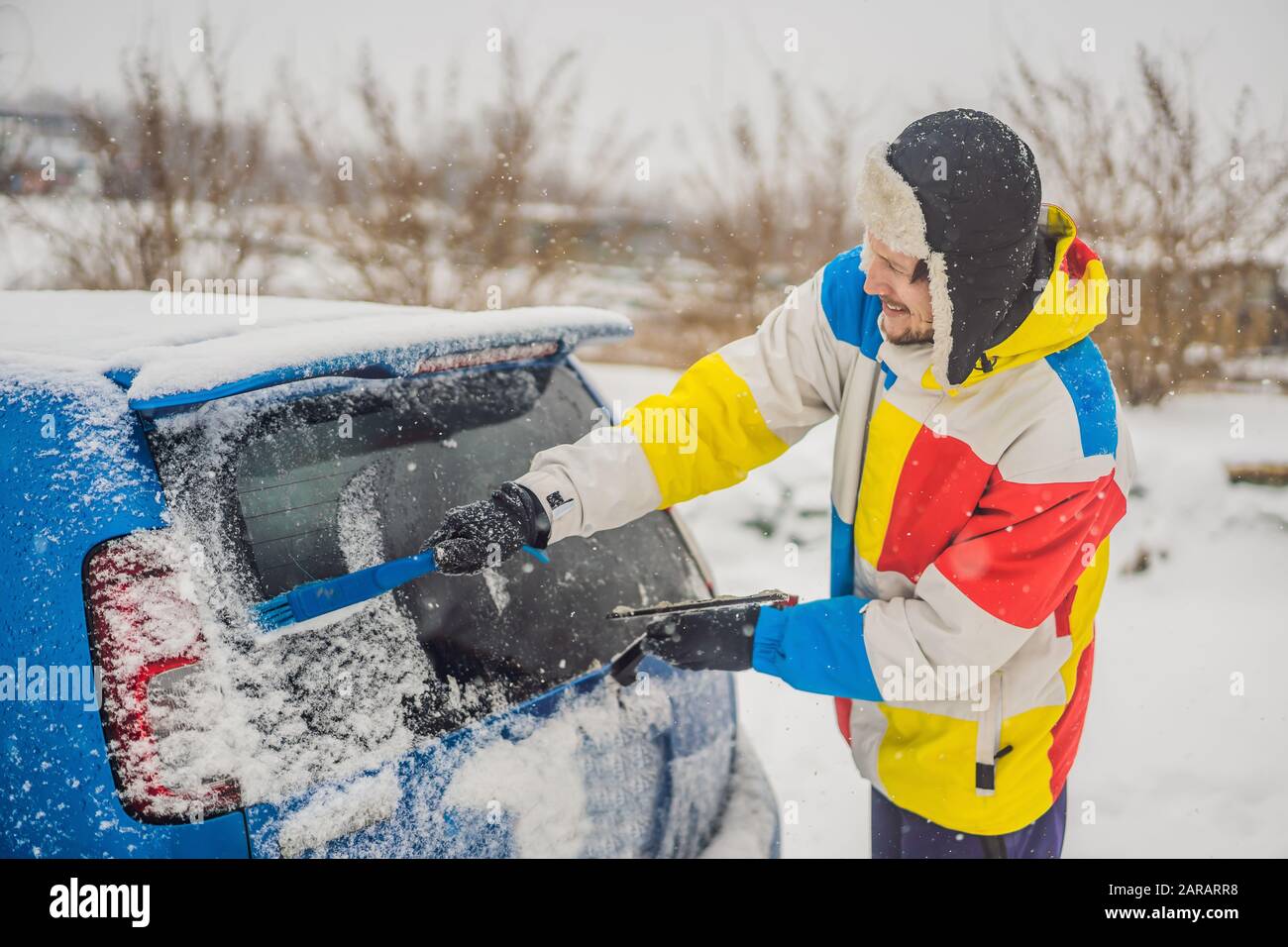 Rimuovere la neve dall'auto con una spazzola Foto Stock