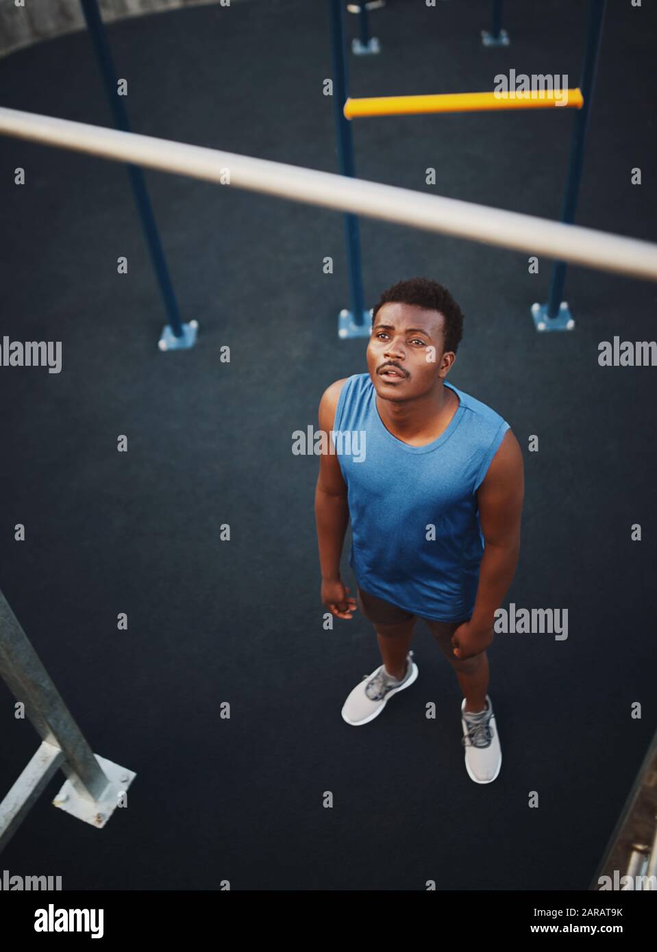 Sicuro misura giovane africano americano uomo che si prepara per l'allenamento su barra orizzontale al parco calisthenics Foto Stock