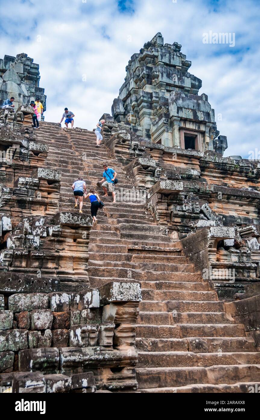 I turisti salgono i ripidi gradini di Ta Keo che conducono alle cinque torri in cima. Siem Reap Cambogia Foto Stock