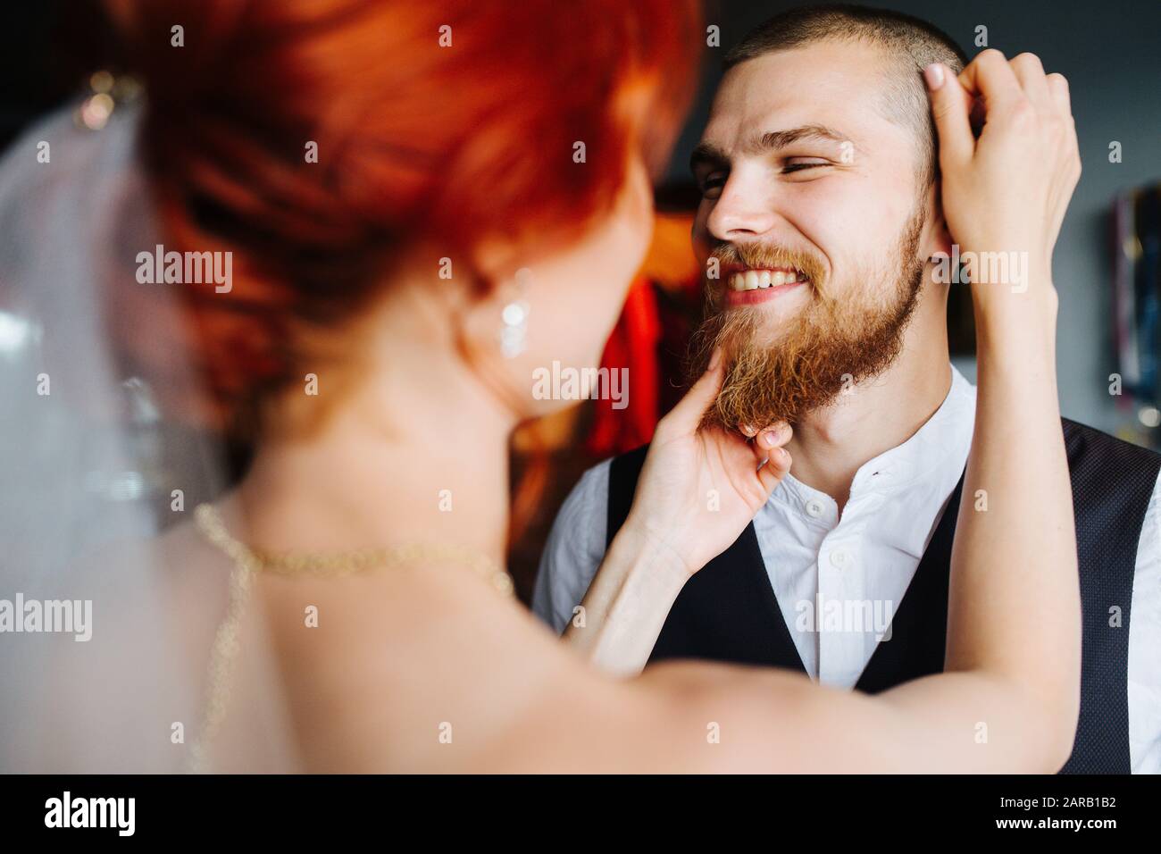 Sposa che si adunerà al suo futuro marito in una stanza luminosa prima della cerimonia di matrimonio Foto Stock