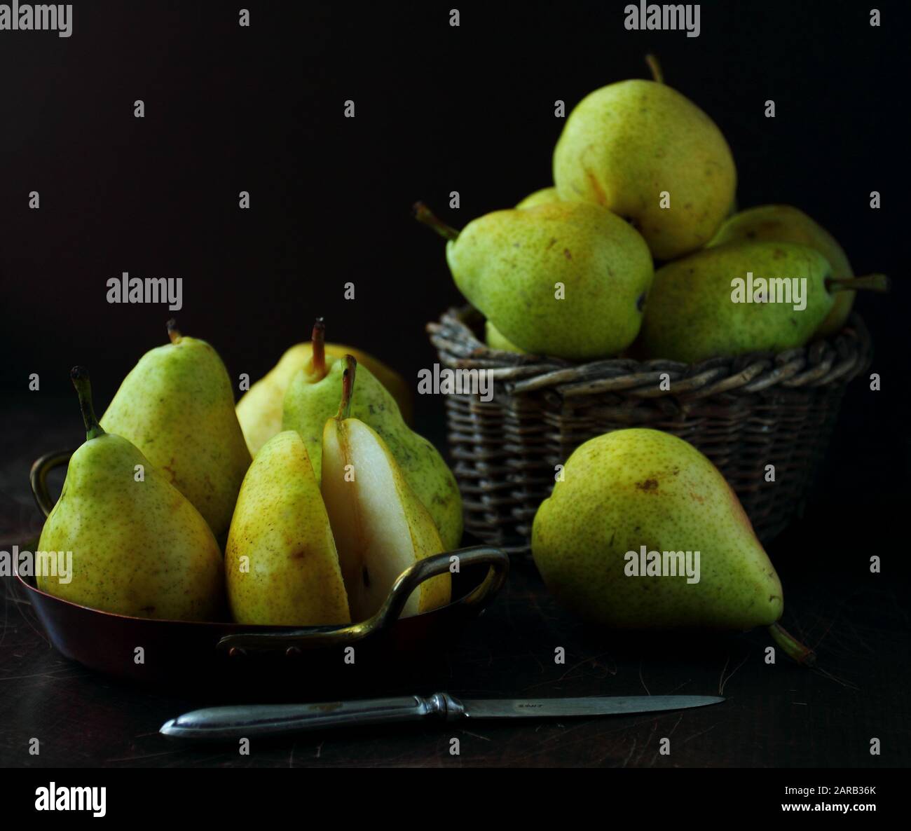 Pere fresche mature su tavola scura su sfondo sfocato Foto Stock