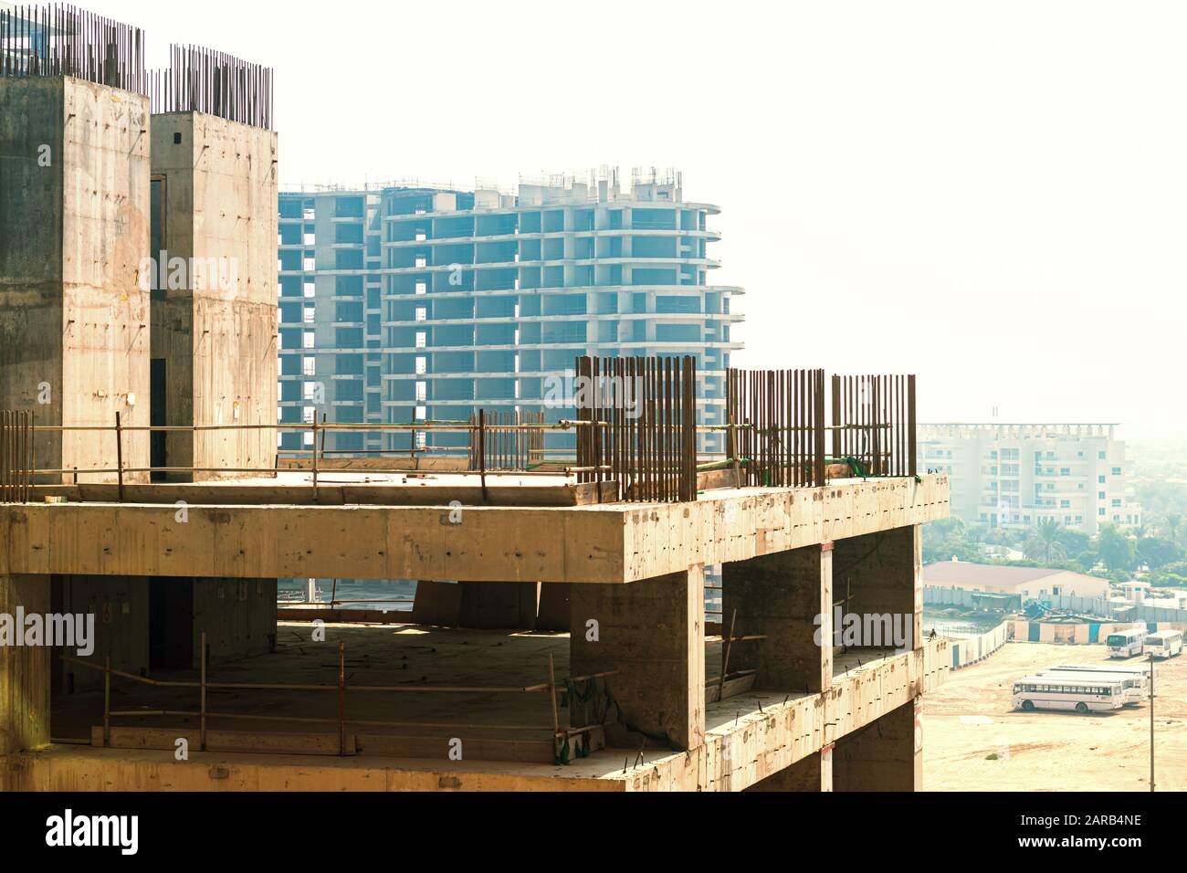 un edificio in costruzione al mattino e altri edifici in costruzione sullo sfondo del lavoratore con gli autobus in mezzo su un san Foto Stock