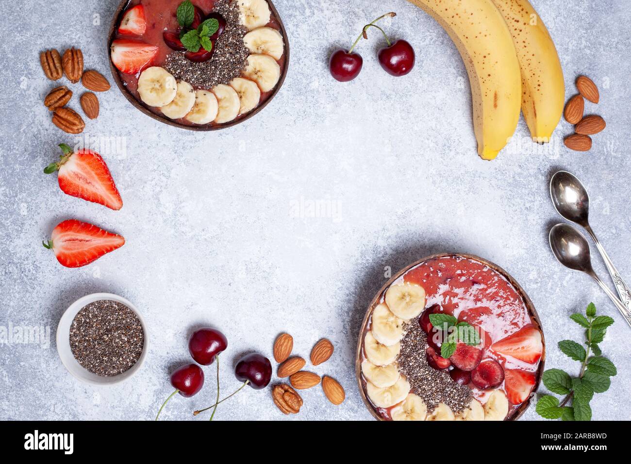 Una sana prima colazione. smoothie ciotola con fragole, ciliegie, chia semi su un cemento grigio Sfondo. vista da sopra. spazio copia Foto Stock