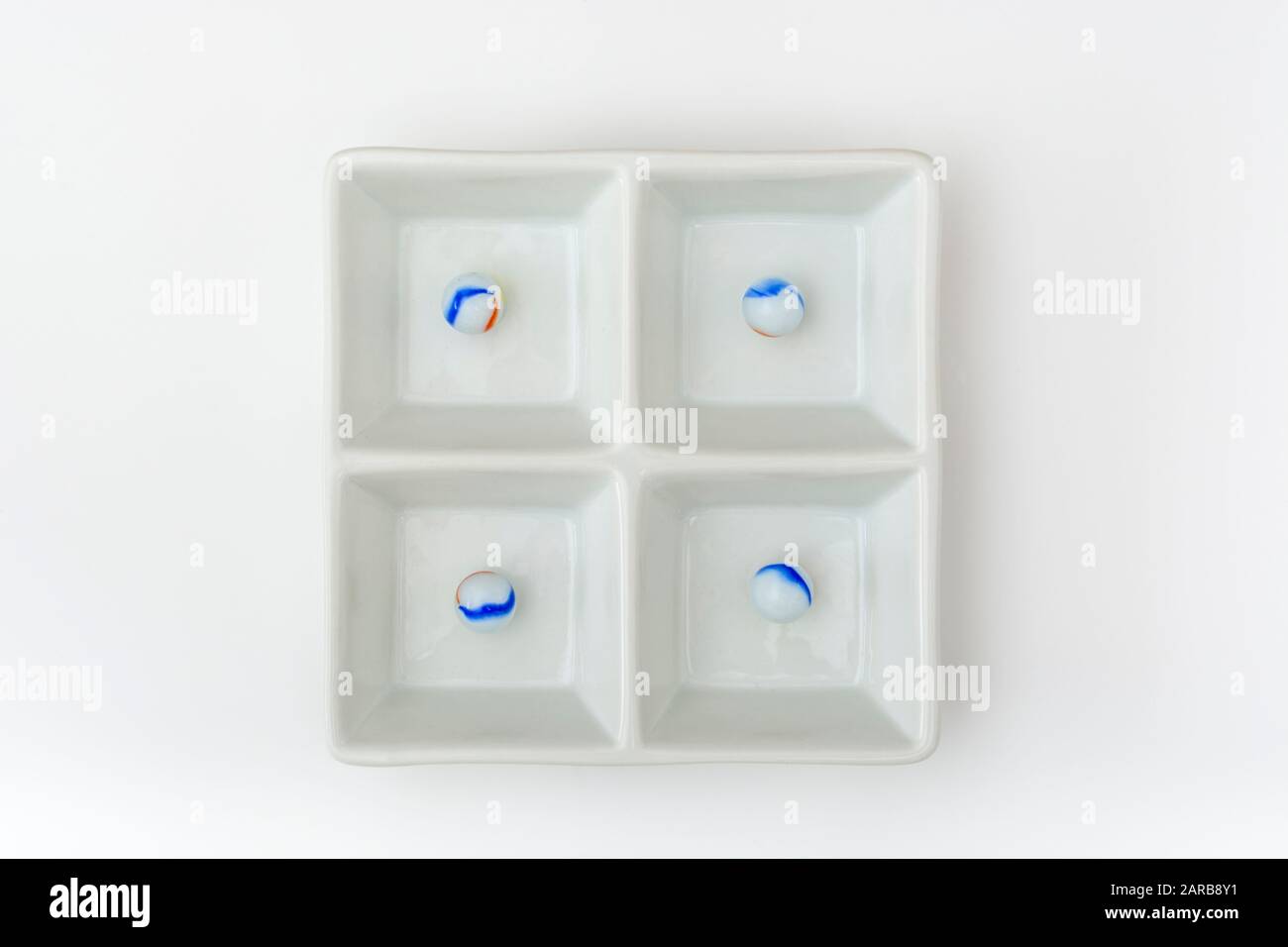 Marmi bianchi - non legati ai marmi Elgin in ceramica piatto - come metafora divisa. Divisi, sfere astratte, marmi giocattolo, perdere i marmi. Foto Stock