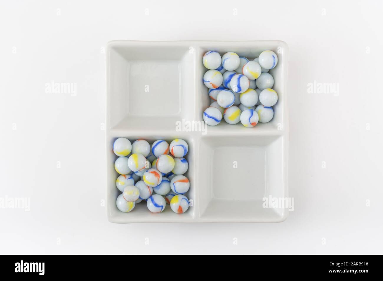 Marmi bianchi - non legati ai marmi Elgin in ceramica piatto - come metafora divisa. Divisi, sfere astratte, marmi giocattolo, perdere i marmi. Foto Stock