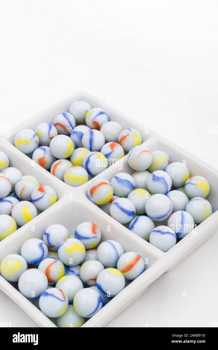 Marmi bianchi - non legati ai marmi Elgin in ceramica piatto - come metafora divisa. Divisi, sfere astratte, marmi giocattolo, perdere i marmi. Foto Stock