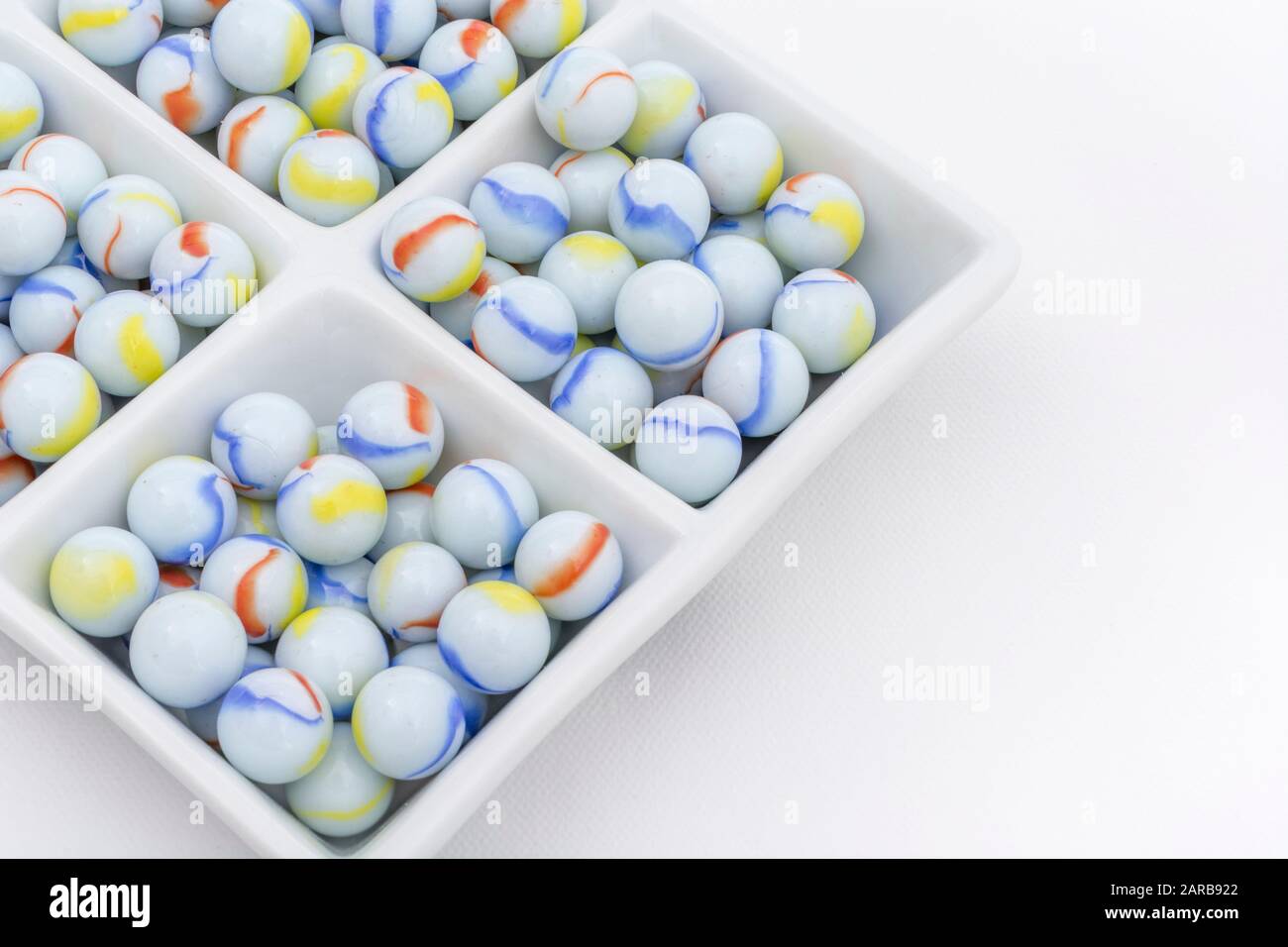 Marmi bianchi - non legati ai marmi Elgin in ceramica piatto - come metafora divisa. Divisi, sfere astratte, marmi giocattolo, perdere i marmi. Foto Stock