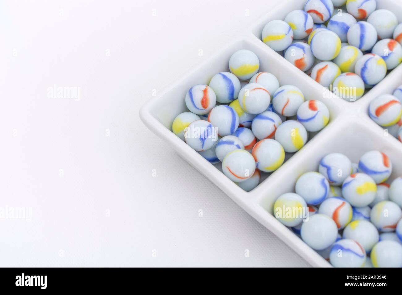 Marmi bianchi - non legati ai marmi Elgin in ceramica piatto - come metafora divisa. Divisi, sfere astratte, marmi giocattolo, perdere i marmi. Foto Stock