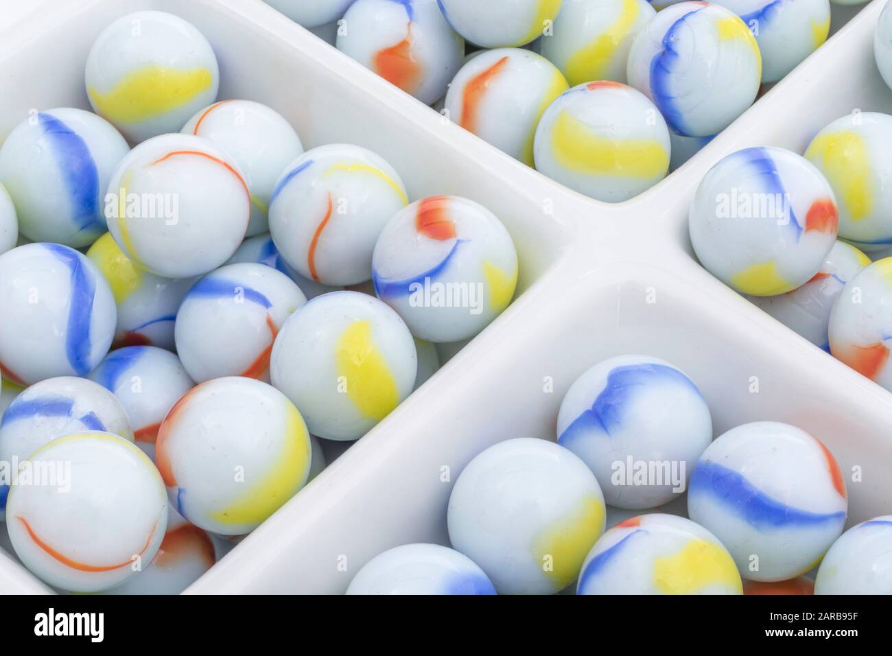 Marmi bianchi - non legati ai marmi Elgin in ceramica piatto - come metafora divisa. Divisi, sfere astratte, marmi giocattolo, perdere i marmi. Foto Stock