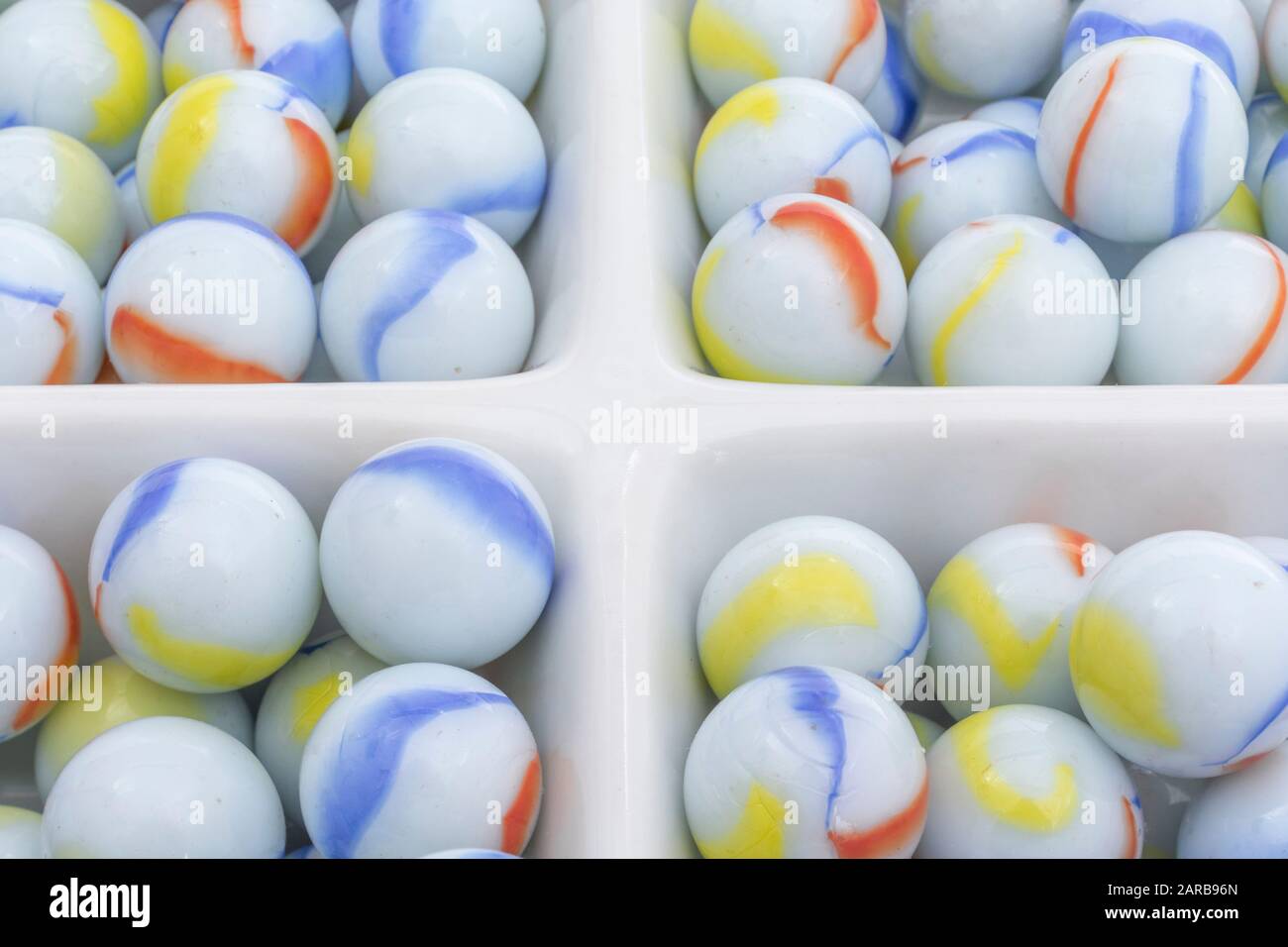 Marmi bianchi - non legati ai marmi Elgin in ceramica piatto - come metafora divisa. Divisi, sfere astratte, marmi giocattolo, perdere i marmi. Foto Stock