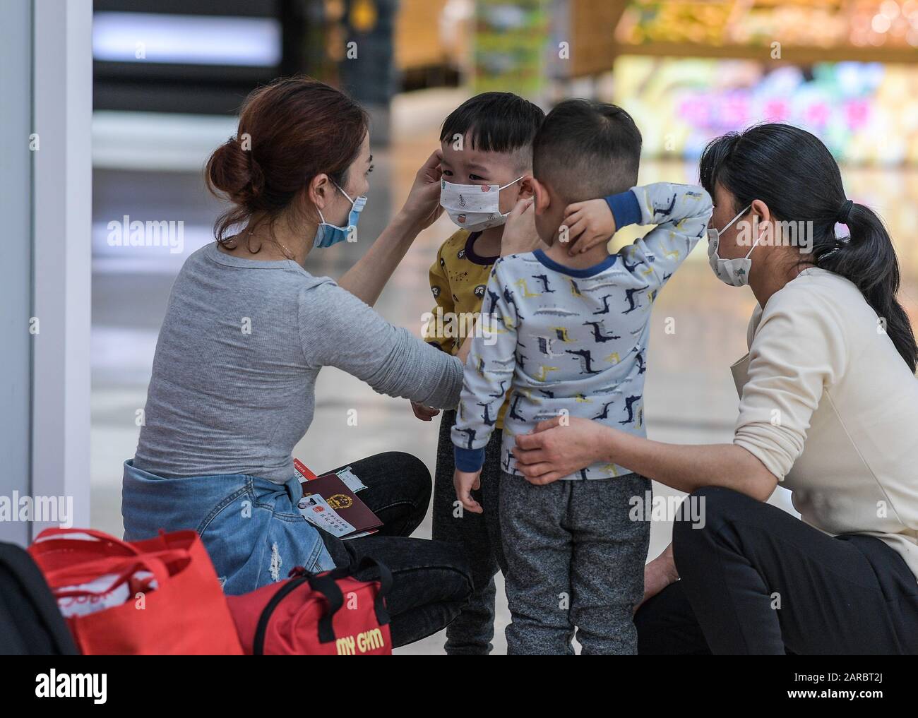 (200127) -- HAIKOU, 27 gennaio 2020 (Xinhua) -- una donna aiuta un bambino a indossare una maschera all'aeroporto internazionale Meilan di Haikou, nella provincia Hainan del sud della Cina, 25 gennaio 2020. Hainan ha suggerito a tutti i residenti e turisti di indossare maschere all'aperto per prevenire la diffusione di nuovi coronavirus. (Foto Di Pu Xiaoxu/Xinhua) Foto Stock