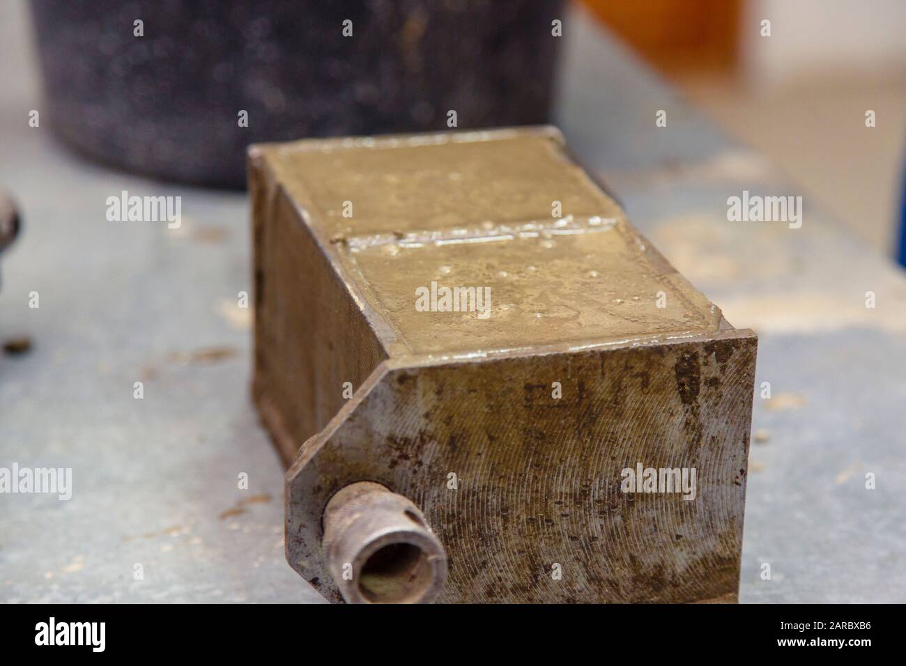 Un membro della costruzione del laboratorio prende un campione di calcestruzzo. Carica il calcestruzzo in uno stampo speciale con un frattazzo. Il risultato è un cu Foto Stock